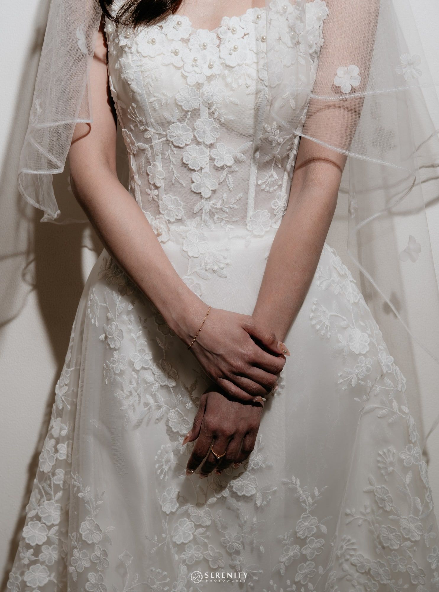 Detail gaun pengantin renda dengan aplikasi bunga tiga dimensi