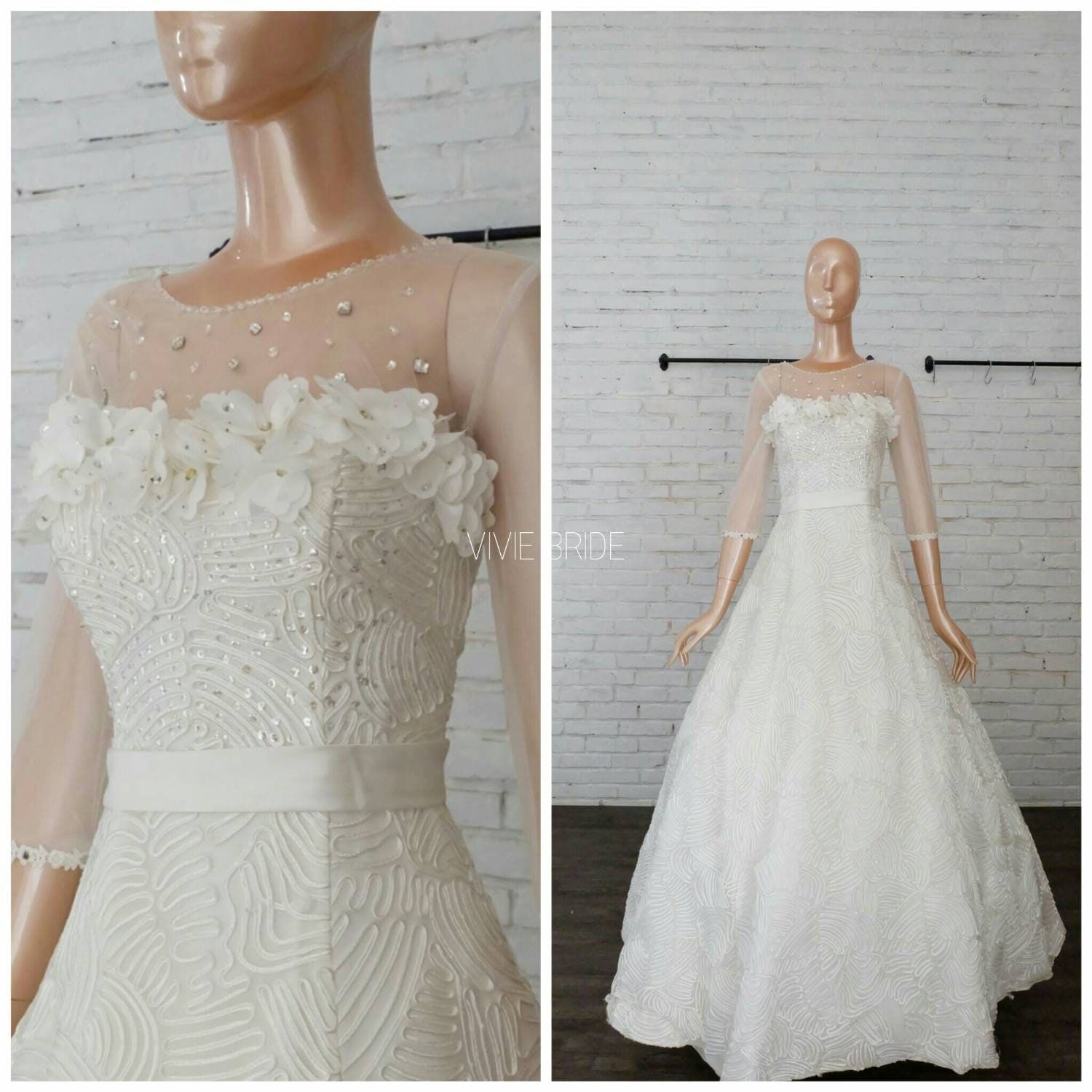 Gaun pengantin dengan illusion neckline berhias bunga pada manekin