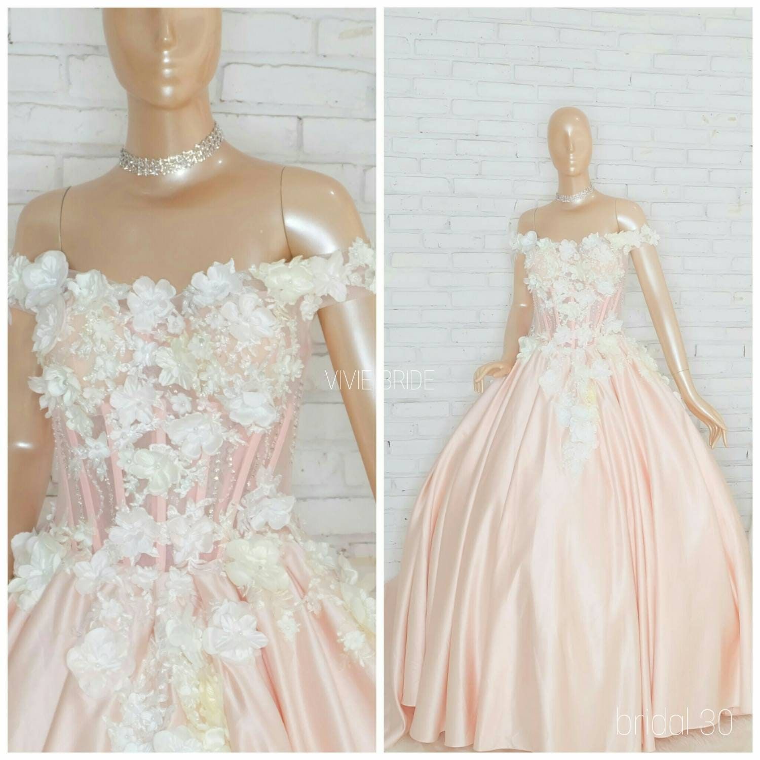 Gaun ball gown warna peach dengan aplikasi bunga pada manekin