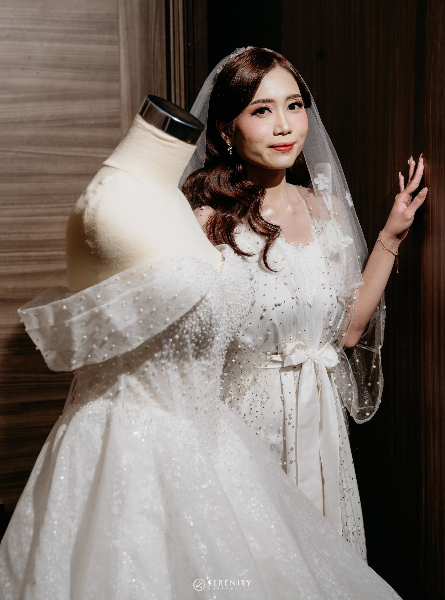 Pengantin wanita berdiri di belakang gaun ball gown berpayet